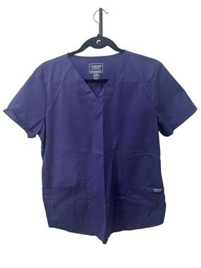 Cherokee Workwear V-neck scrub top is shown in a grape purple women size M